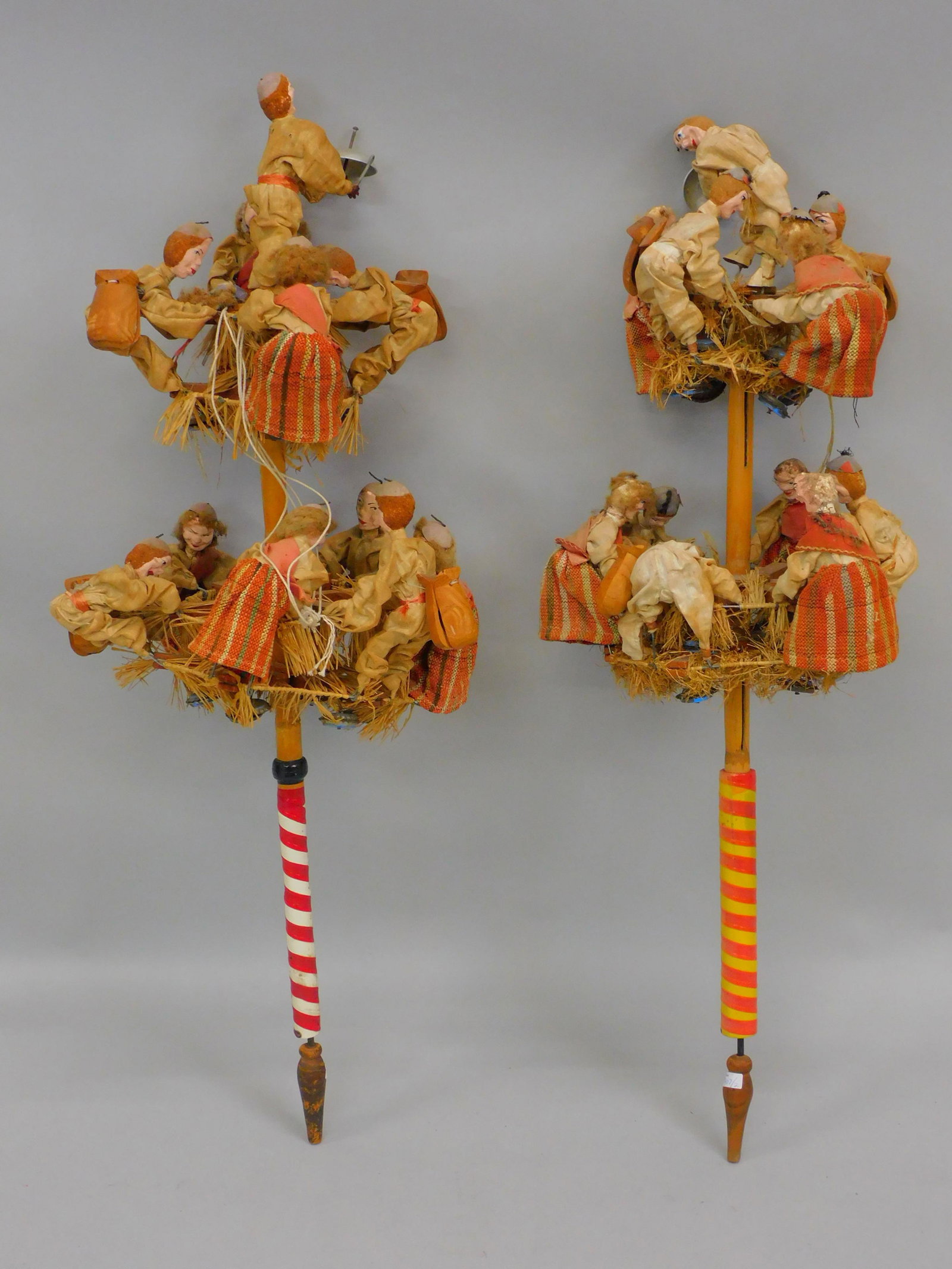 (2) Azorean mechanical folk-art parade: noise-makers. Polychrome painted decoration, handmade, hand sewn clothes. Some wigs missing or loose. Most figures have castanets on back. Each measures 36" high, 15" diameter.