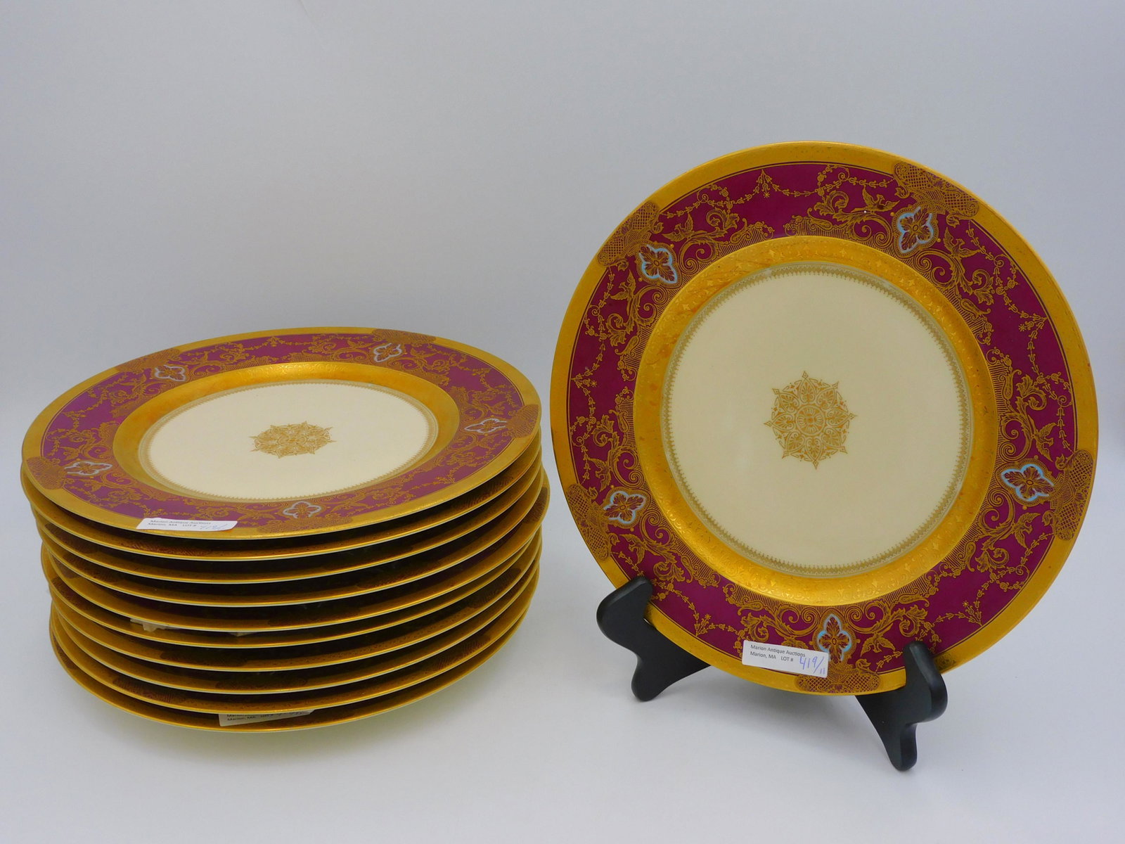 A set of 11 Czechoslovakian Perkin Hammer: porcelain dinner plates. 10 3/4" diameter. Gold gilt decoration and maroon border. Excellent overall condition.