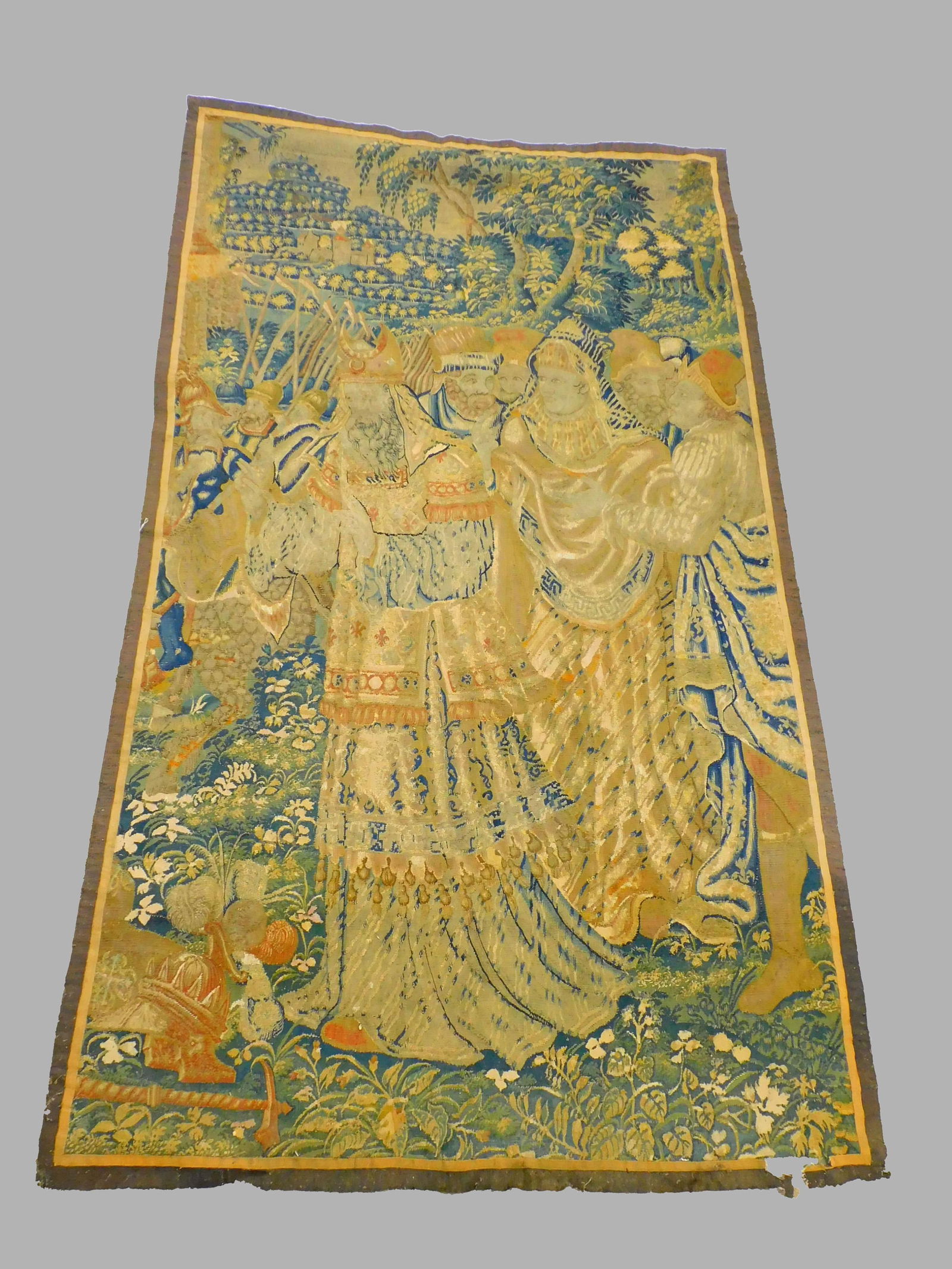 Flemish tapestry. 17th/18th-century. Depicting: noblemen, religious leaders, military escort in background, castles and trees. 55" wide by 96" long. Age-appropriate wear. Shows loss to border at base.