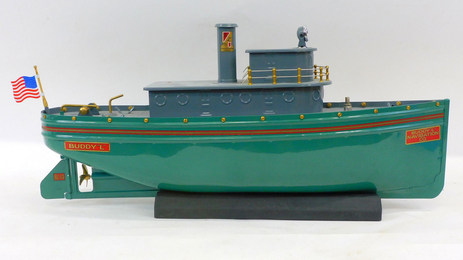 Buddy L Tug Boat Number 3000. Painted pressed: steel. On the bow "Buddy L Navigation Co". Made by T-Reproductions, Johnson City Tennessee. Painted pressed steel, green with grey black deck, red, grey pin striping, three-blade brass screw propeller