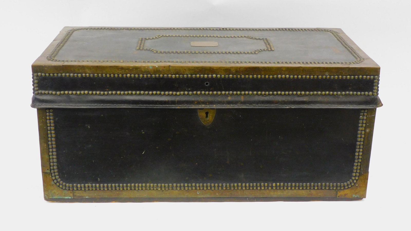 Brass and leatherbound camphor wood chest.: 19th-century. Brass handles. Brass plaque with owner's initials. 13" high by 29" wide by 15 1/2" deep. Shows some roughage to lid leather rim band.