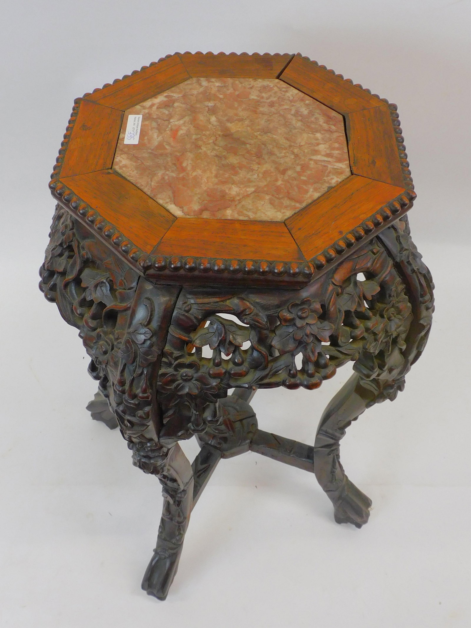 Rosewood stand with inset octangle marble top.: Early 20th-century. Elaborate carving. 24" high by 12 1/4" wide. Slight separation on top panel. Otherwise, good condition.