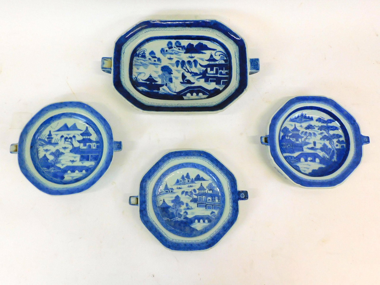 (4) Canton Chinese export warming dishes.: 19th-century. Blue and white porcelain. (3) measure 11" x 9". The larger dish is 15 1/2" x 10. No visible damage.