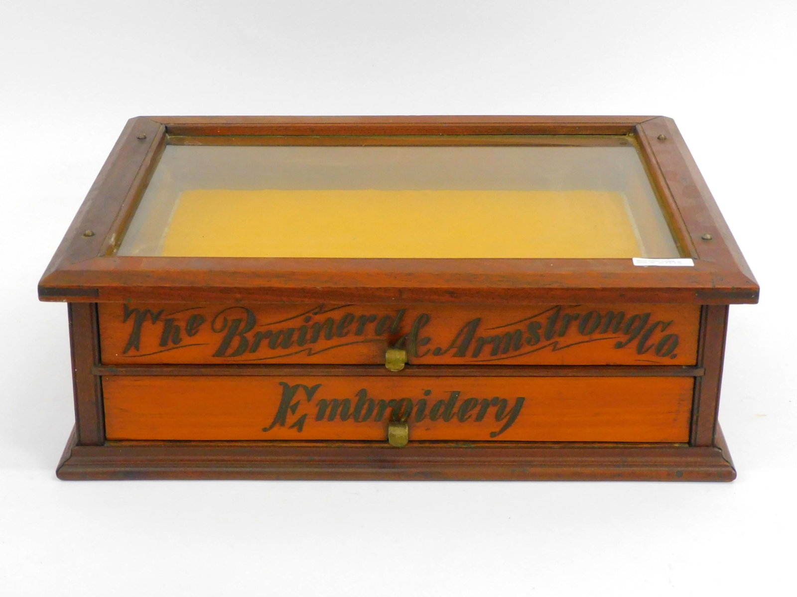 An Advertising Display Cabinet. 19th century. A: walnut thread display case for the Brainerd and Armstrong Company Embroidery. Glass display top. 7" high by 21" wide by 15 1/2" deep. Very good condition. Original finish.