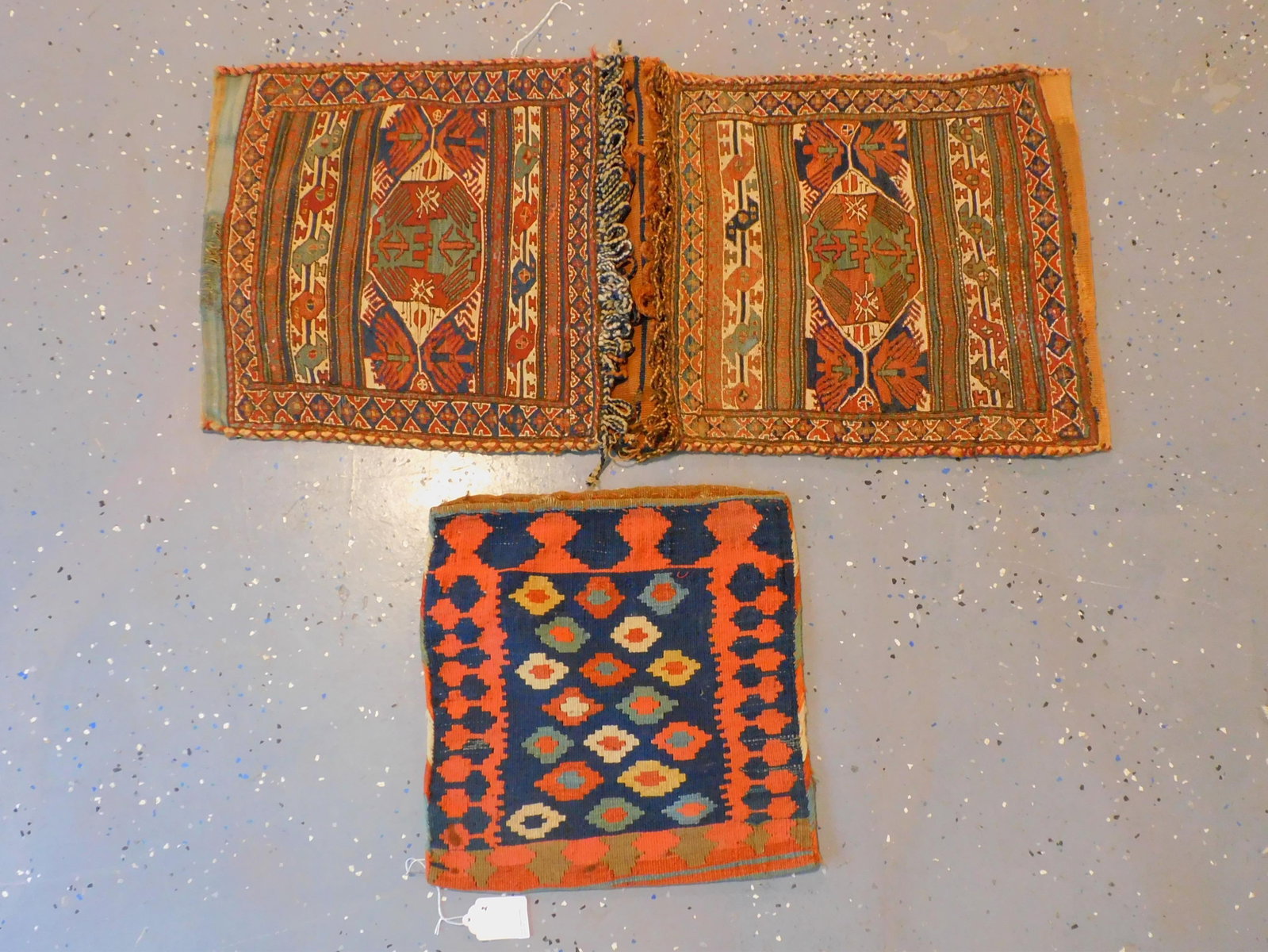 (2) Oriental Saddle Bags. Early 20th century. To: include a Sumak (Soumak) with geometric design. 19 1/2" by 43". Good overall condition. Kilim with striped and geometric design. 17 1/2" by 17 1/2". Age appropriate wear.
