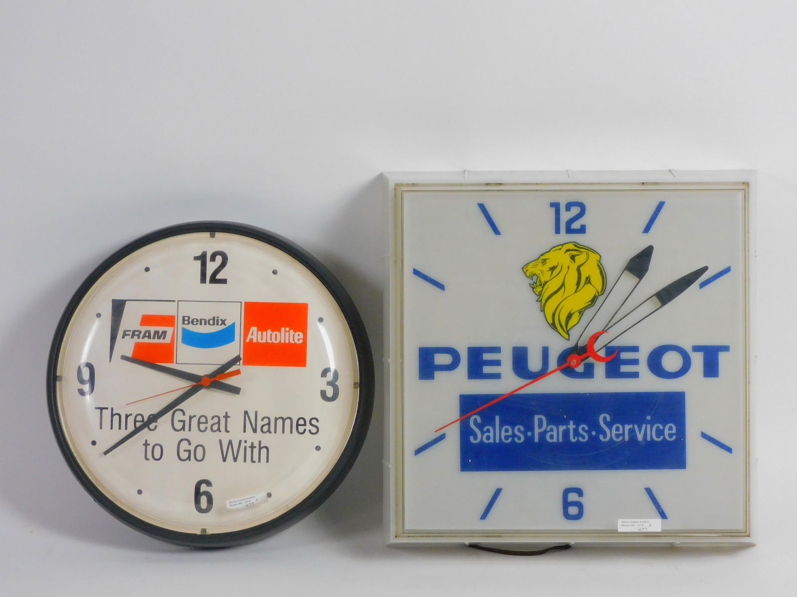Two vintage advertising clocks to include Peugeot: sales, parts, and service. 15 1/2" by 4 1/2" deep, clock is working, light is not no bulb present along with a battery operated Fram Bendix Auto Lite advertising clock not working needs battery 14" di