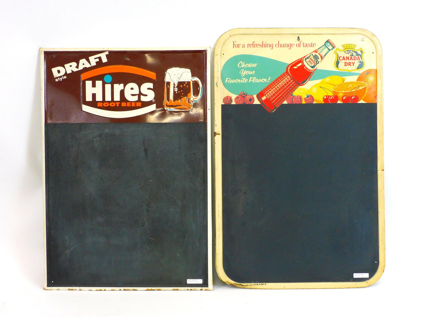 Two advertising metal chalkboard signs to include: draft hires root beer 28" by 19 1/2", shows where and rust on edges. Canada Dry, 30" by 19 1/2", wear and rust on edges.