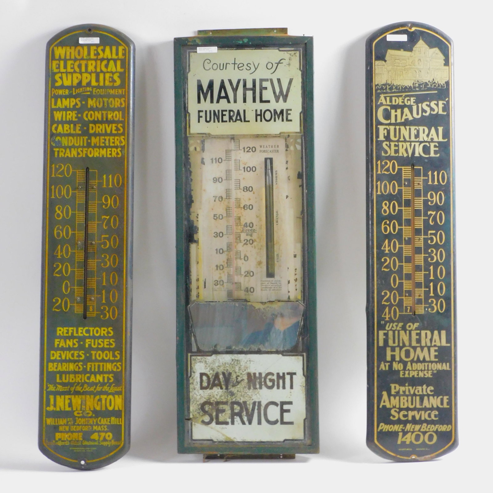 Three vintage metal advertising thermometers to: include Mayhew Funeral Home which is also a barometer, 38" high by 12" wide. Shows substantial wear to trim decoration, bottom glass section is cracked, frame is rusted. J. Newington Company. Wholesal
