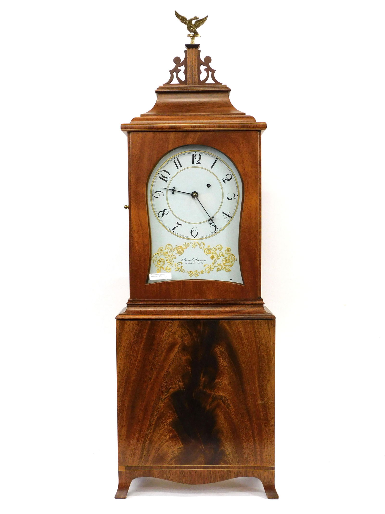 Elmer O. Stennes Shelf Clock. 20th century.: Mahogany shelf clock made in Weymouth, Massachusetts. Weight driven, brass eagle finial, shaped crest fretwork, painted and gilt dial, veneered base with French feet. The case is stamped, M.C.I.P. (Ma