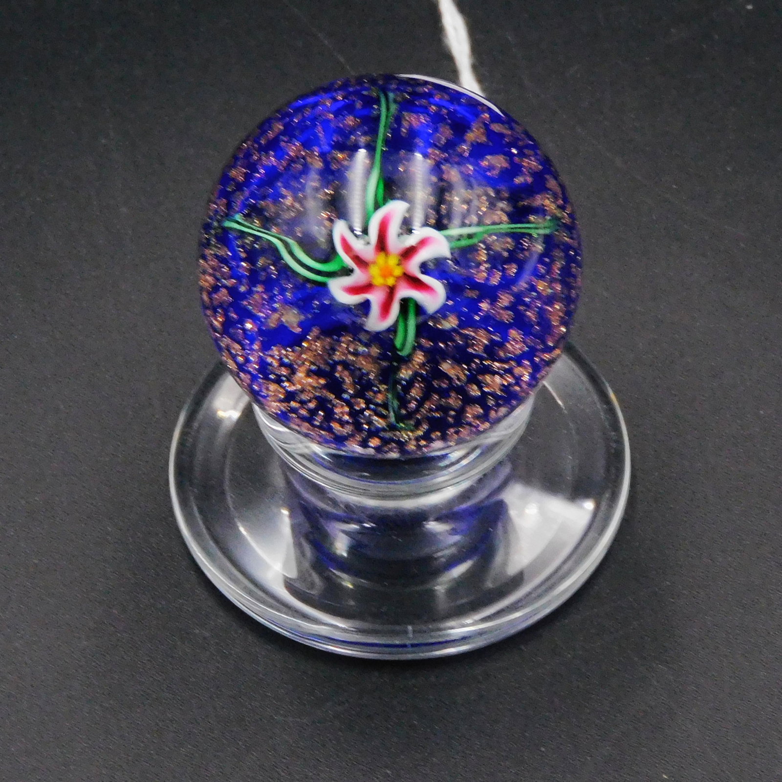 Kazian pedestal paperweight, blue ground with: gold flakes, center flowers, marked with a small "K", 1 3/4" high, 1 5/8" diameter.