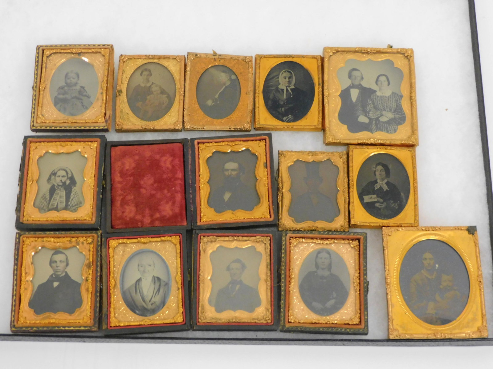 (14) Victorian Photographs. 19th century,: depicting people of various ages. Mostly ambrotypes. In period gilt metal frames. Range in size from 2 1/2" x 2" to 3 1/4" x 2 3/4". Most are missing the covers to their fitted cases, or the cases ent