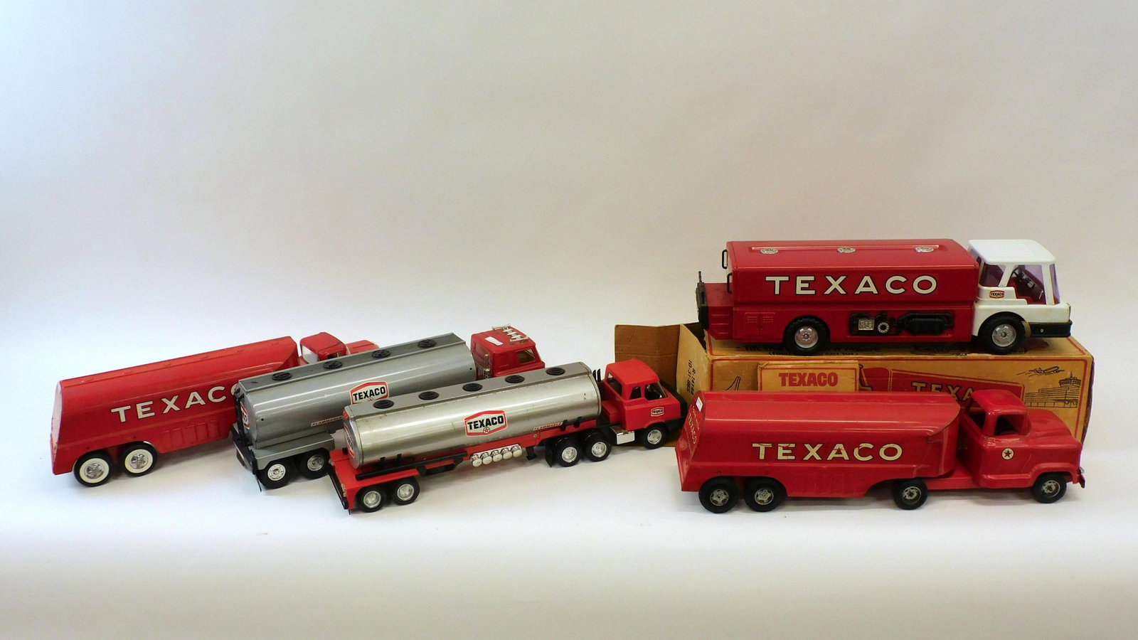 (5) Texaco Tanker Truck Toys: 20th c.; (2) Buddy-L pressed steel, red painted finish: 23 1/2" L together with three plastic and metal tanker trucks ca.1970-80: 21 1/2" - 23" L. All in good overall condition