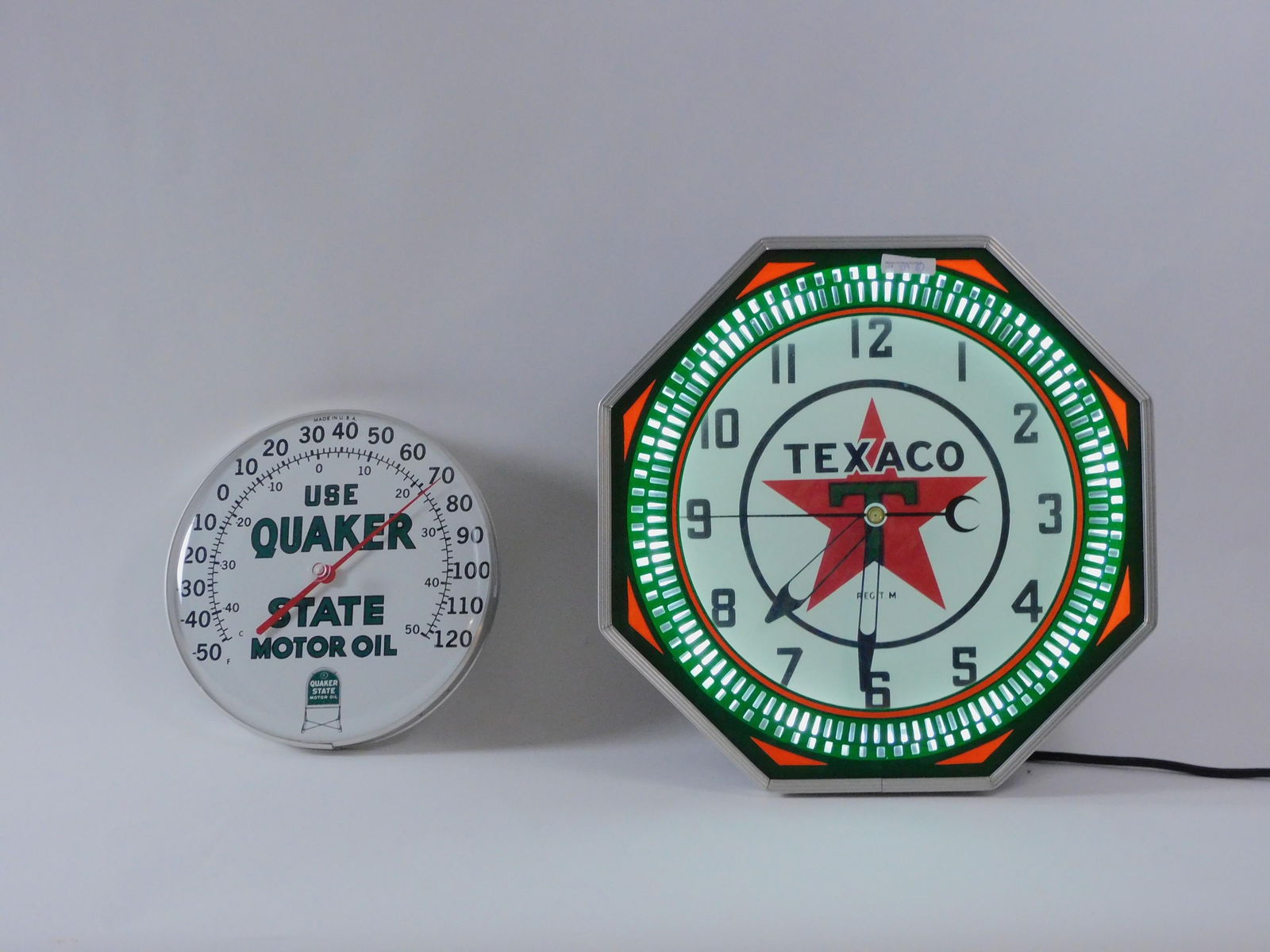 Texaco Clock And Quaker State Thermometer: Illuminated wall clock in octagonal case: Light working, clock not working, 18 1/4" H x 18 1/4" W. Thermometer 10" dia.