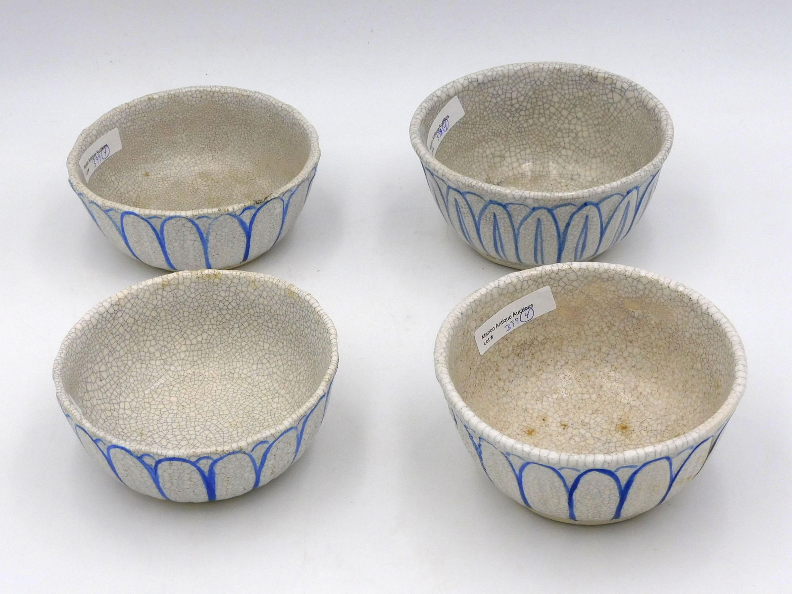 (4) Dedham Pottery Lotus Bowls: Raised rabbit ears around sides. One bowl with Dedham Historical Society exhibition label was broken and repaired: 2-5/8" H x 5 1/4" dia. Second bowl: 2 1/2" H x 5 1/4" dia. Blue mark. Third bowl 2 1/