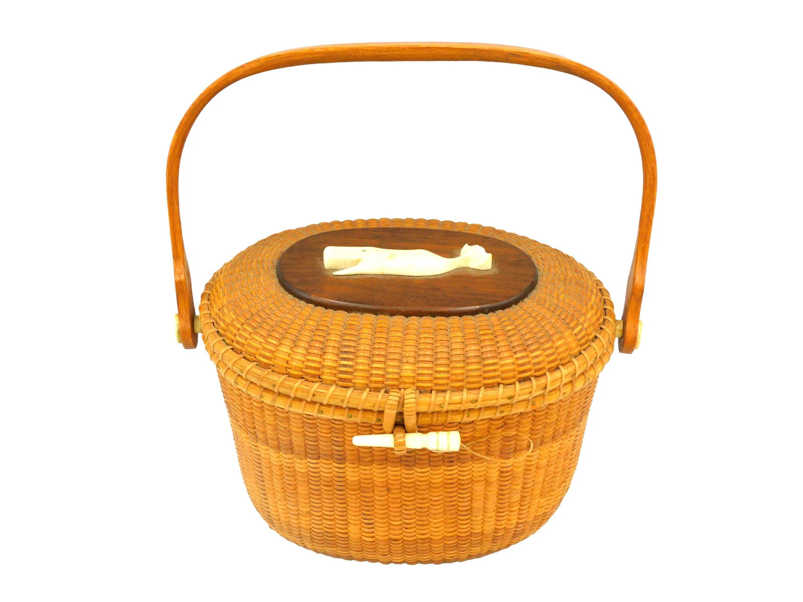 Whaler's Crafts Nantucket Friendship Basket Purse: Dated 1965; oval shaped with swing handle. Carved sperm whale mounted on top of hinged lid. 7-1/2" h (plus handle) x 9" w x 7" d. Good overall condition, no loss to caning. PLEASE NOTE: This item cann