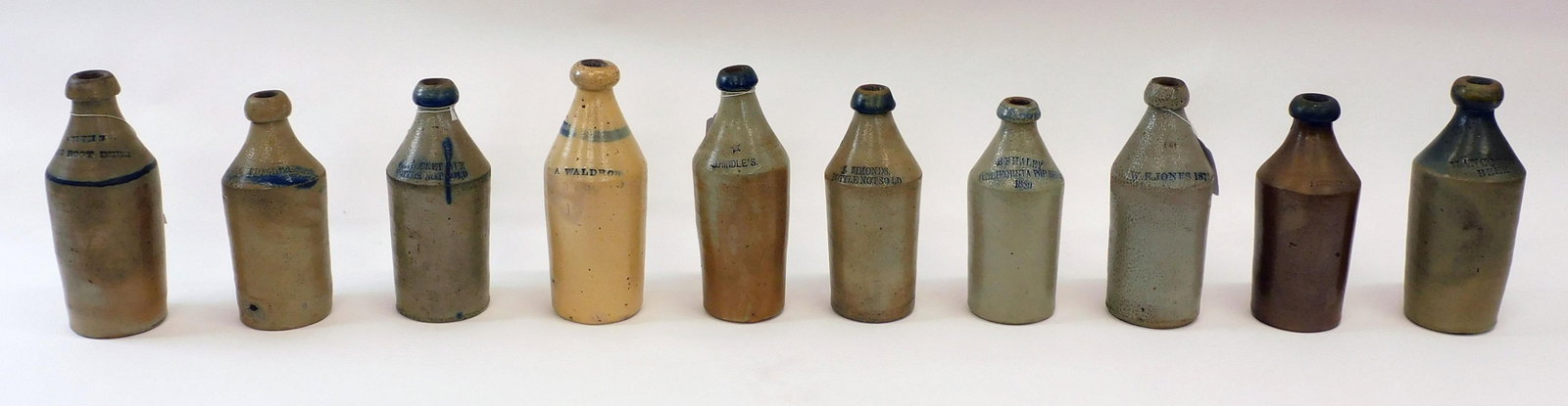 (10) Stoneware Bottles, Cobalt Blue Highlights: To include: A. Waldron, Samuel Fowler, J Hindle's, Pentucket Ale, Smith's White Root Beer - minor roughage to blob top, C Chester, J Simonds, BF Haley California Pop Beer 1889 - chip to rim, W E Jones