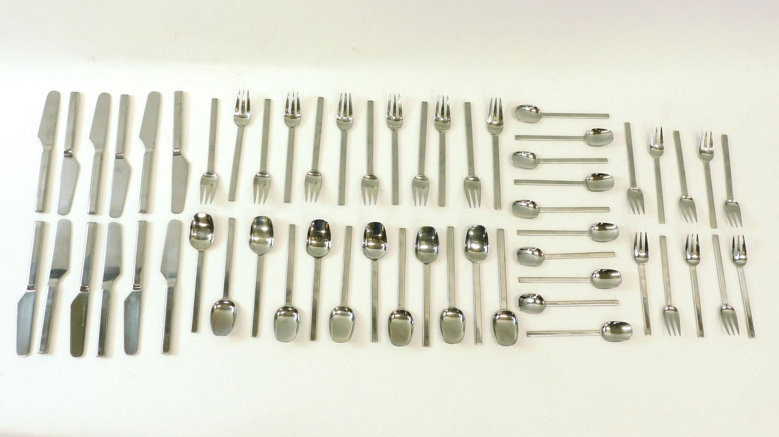 Ward Bennett For Supreme Cutlery Flatware Set: 20th c. (56) piece stainless flatware set to include (12) 7 3/8" forks, (12) 7 3/8" soup spoons, (12) knives 8 1/2" (10) salad forks 6 3/8" (10) teaspoons 6 1/4" Very good condition.