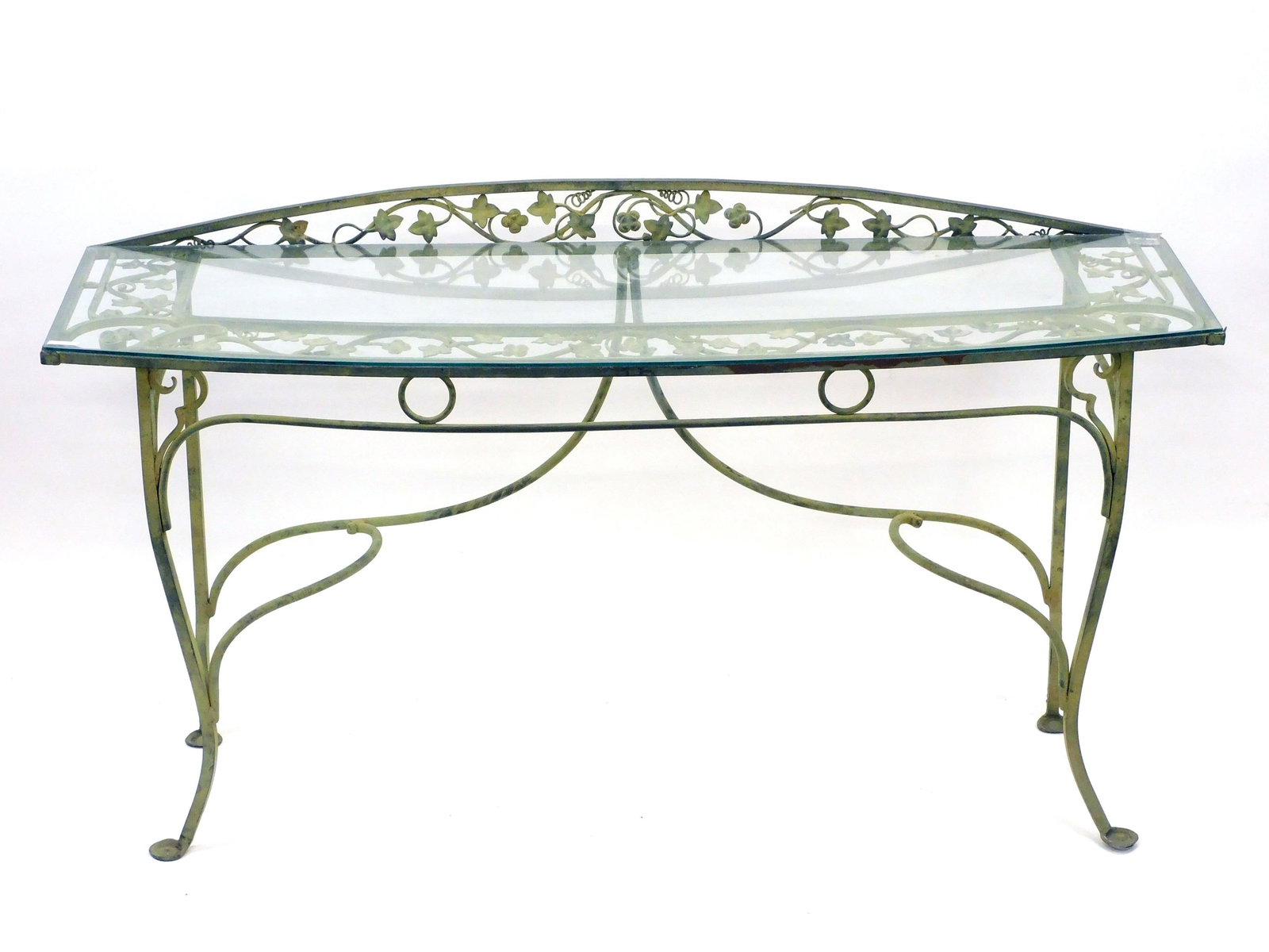 Ornate Wrought Iron Console Table: 20th century. Table has glass top leaf and vine design, bow-front with backsplash. 36" high x 66" wide x 22" deep. Old painted surface. Good condition with small repair to corner of glass top.