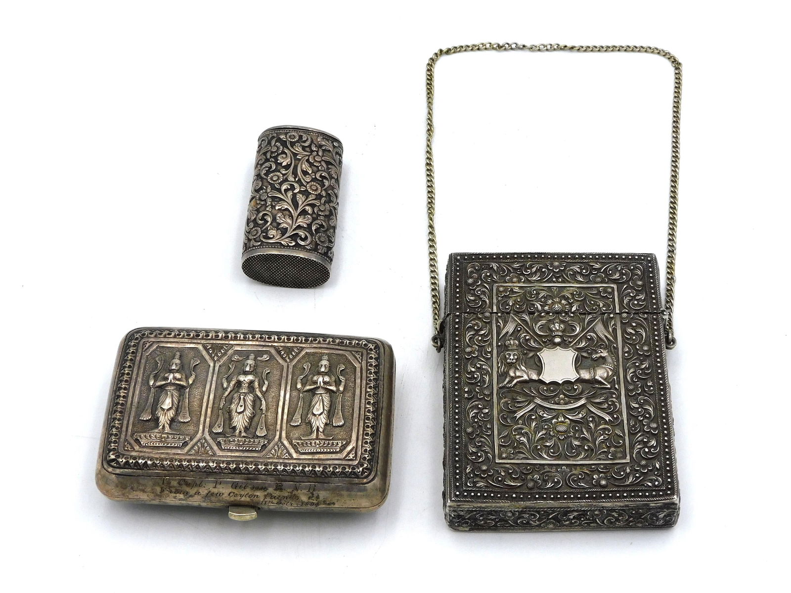 (3) Anglo-Indian Silver Boxes: Late 19th/ early 20th century. To include: A) Repousse silver cigarette case. Engraved with dedication "To Capt. P. Gibson R.N.R. // From a few Ceylon friends/ 11th Oct. 1894". Repousse design of Hind