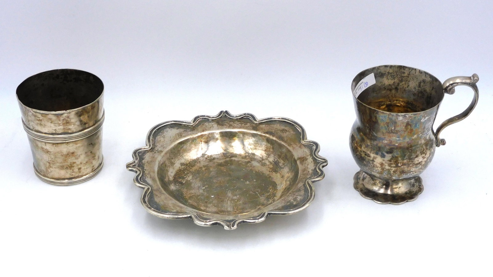 (3) Pieces Spanish Colonial Silver: To include: A) Bowl with shaped edge, 1 1/2" high x 8 3/4 diameter. B) Beaker, 4" high x 3 3/4" diameter. C) Handled mug, 5 1/2" high x 5 1/4" wide x 3 3/4" diameter. Total weigh 36.03 ozt. Shipping R