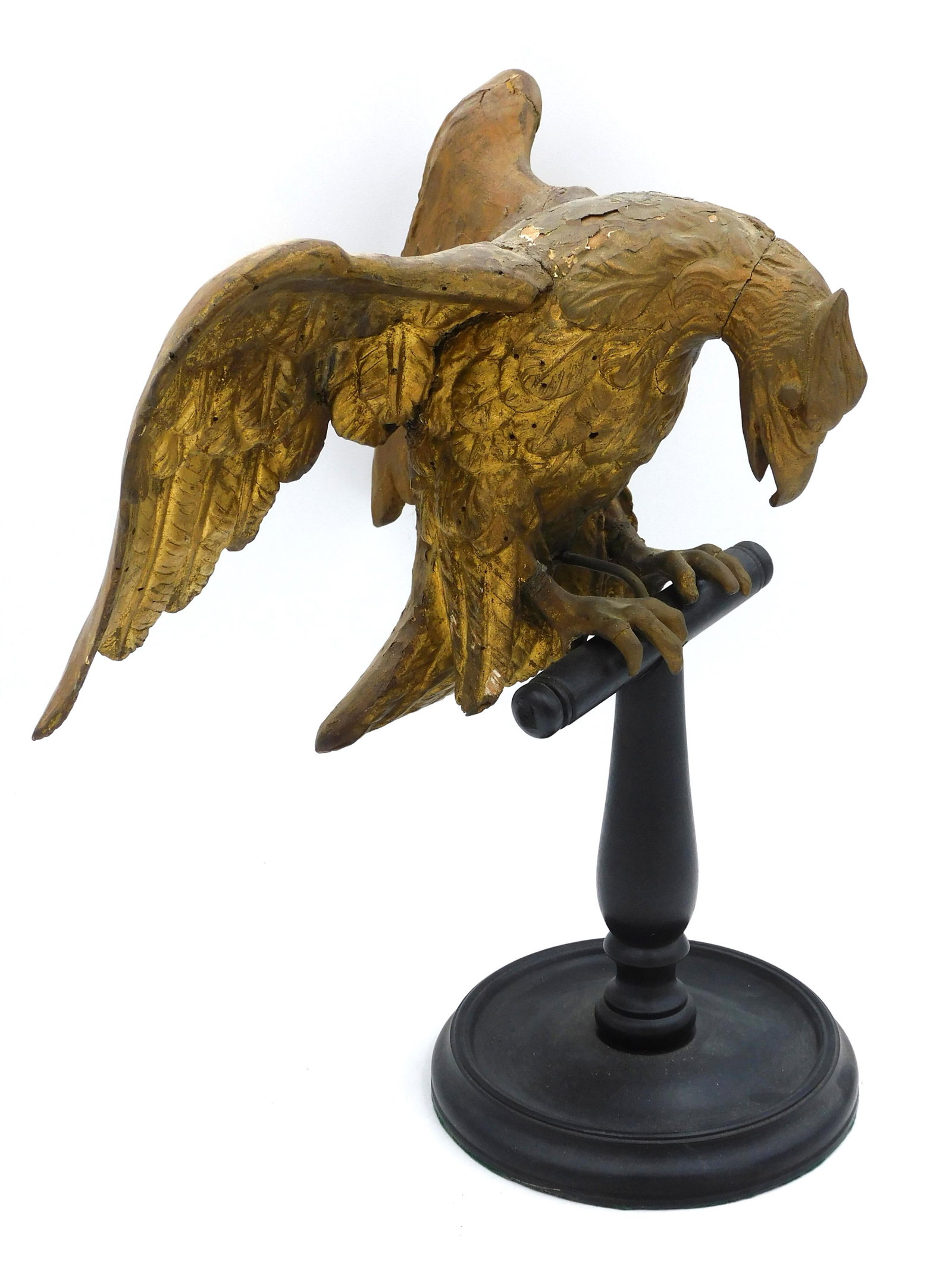 Carved Wooden Eagle: 18th century. Old gilded finish. Mounted on a 19th century wooden stand. 15" high x 11" wide. Shows age appropriate wear and numerous old worm holes. Wing and feet show signs of old repair. Provenance