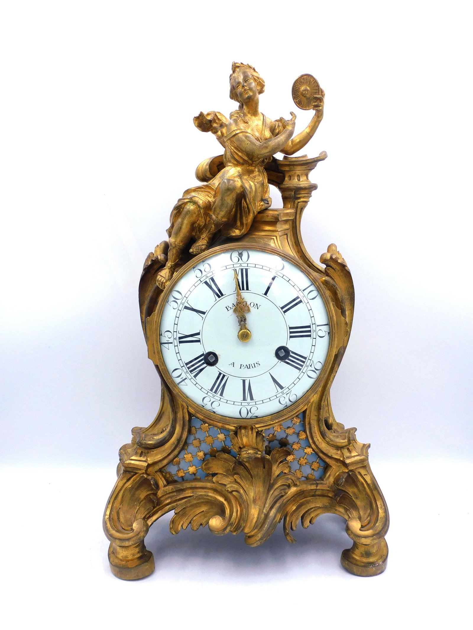 French Rococo Baillon Gilt Figural Mantle Clock: Probably Louis XVI. Late 18th century with allegorical figure of a woman holding a sun medallion with an image of the sun. Enameled dial signed "Baillon, A. Paris". 22" high x 13" wide x 7" deep. Keys