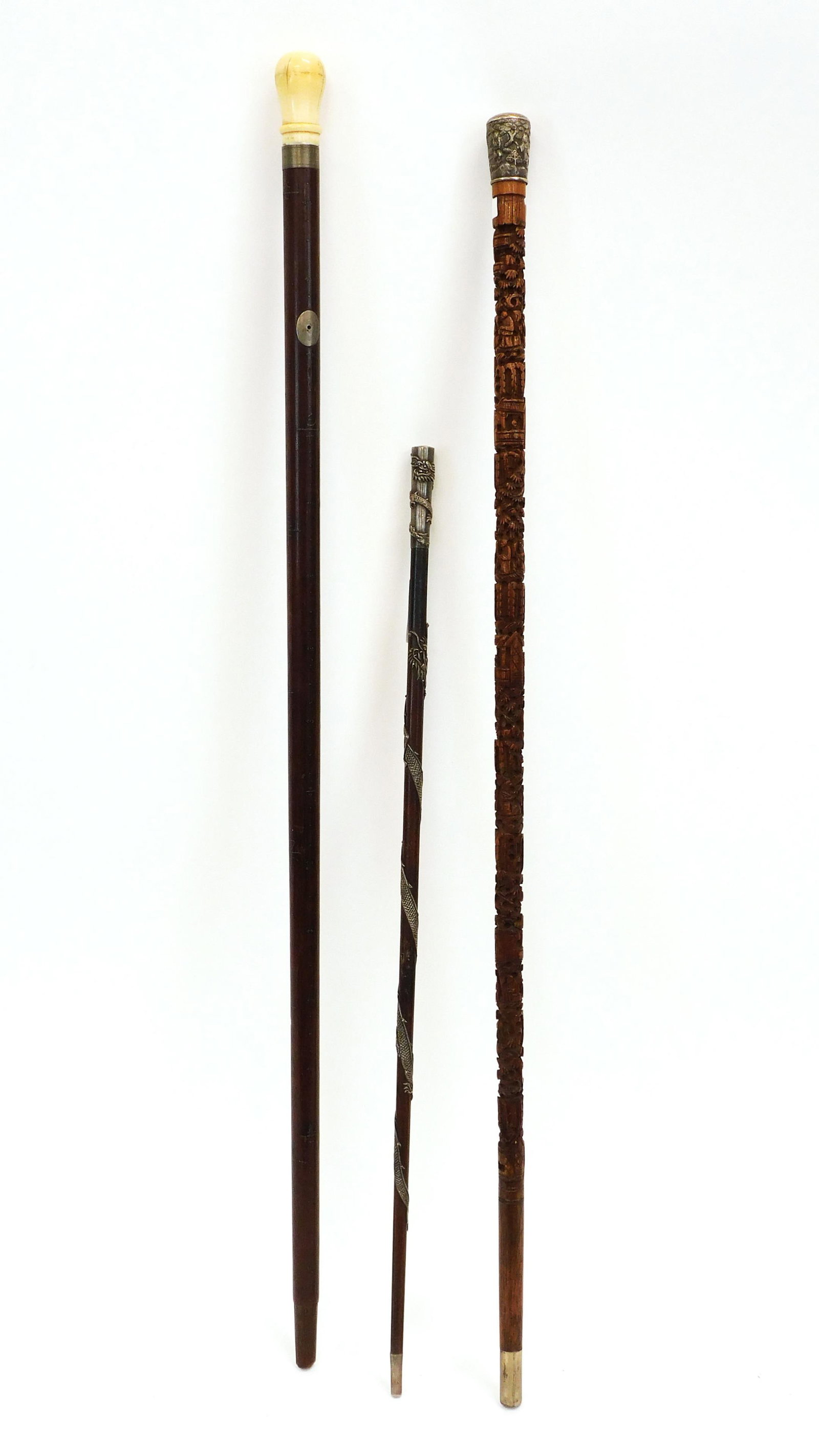 (3) Chinese Walking Sticks: 19th century. To include: A) Mahogony with turned tooth handle and built-in spyglass with a silver mount featuring Chinese characters inlaid along the shaft. 36" long. Missing its tip guard. B) Chines