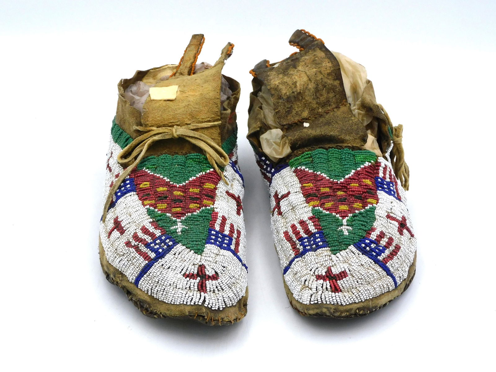 Pair of Sioux Beaded Moccasins: Circa 1890s. American flag motif with various geometric designs. Approx. 10 1/2" long. Overall good condition with age appropriate wear.