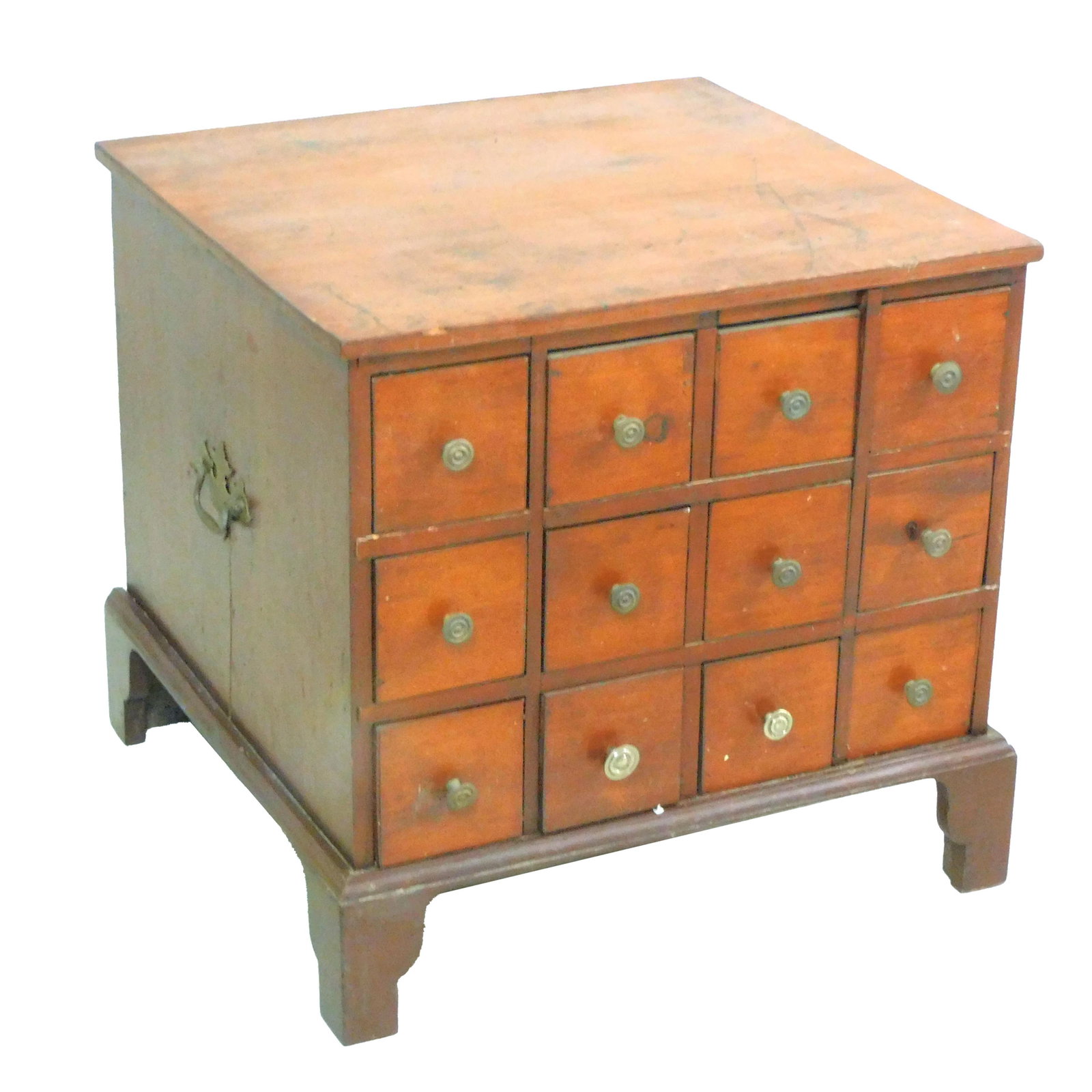 Twelve-Drawer Apothecary Chest: Early 20th century. New England walnut and pine chest with brass pull and side handles mounted on a bracket base. 24" high x 24 3/4" wide x 24 3/4" deep. Age appropriate wear with age shrinkage cracks