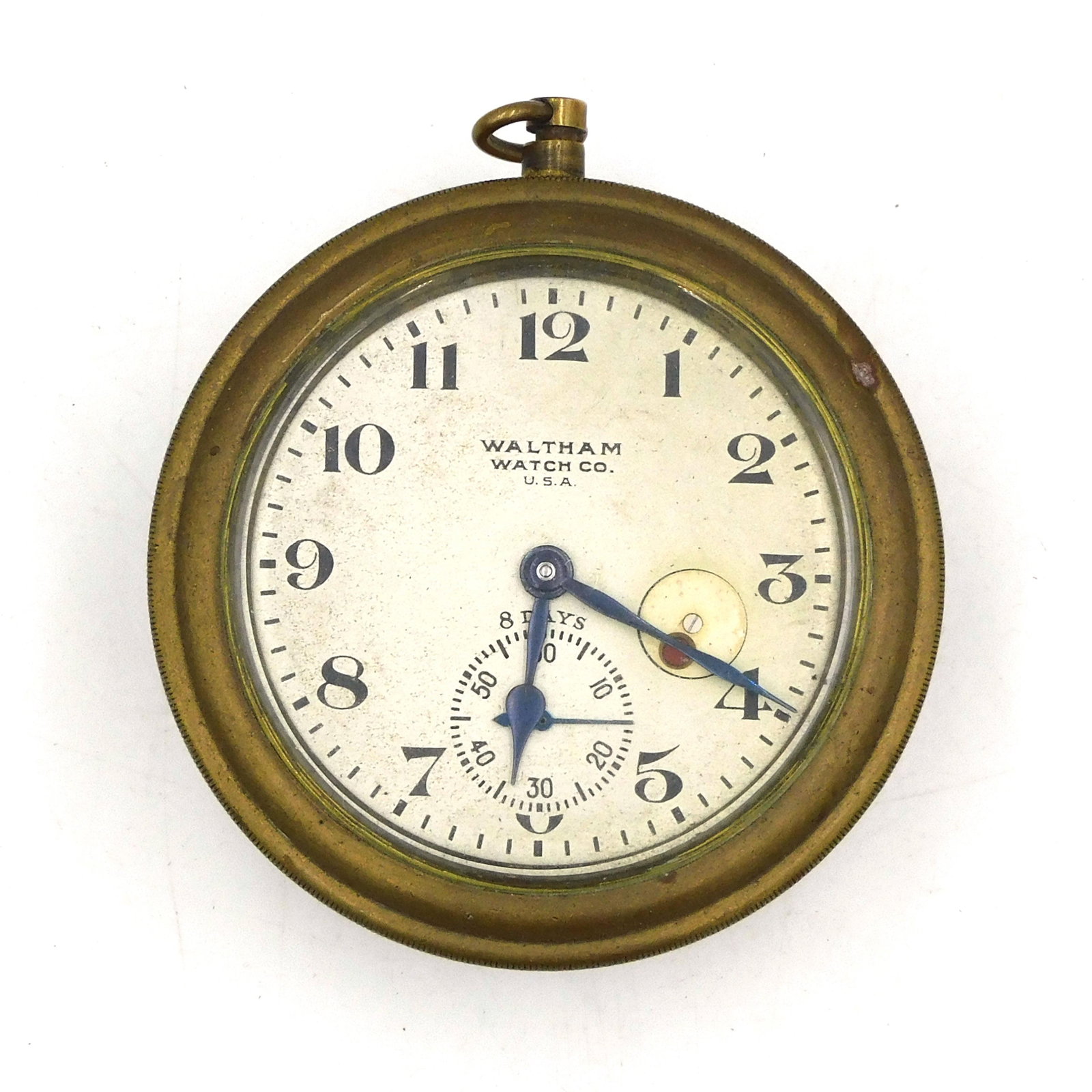 Miniature Waltham Brass Clock: Likely an automobile clock. Round brass case with 8-day movement with seconds hand and with pendant wind and set. 3" diameter x 1 1/2" deep. Presently working but not guaranteed. Provenance: From the 