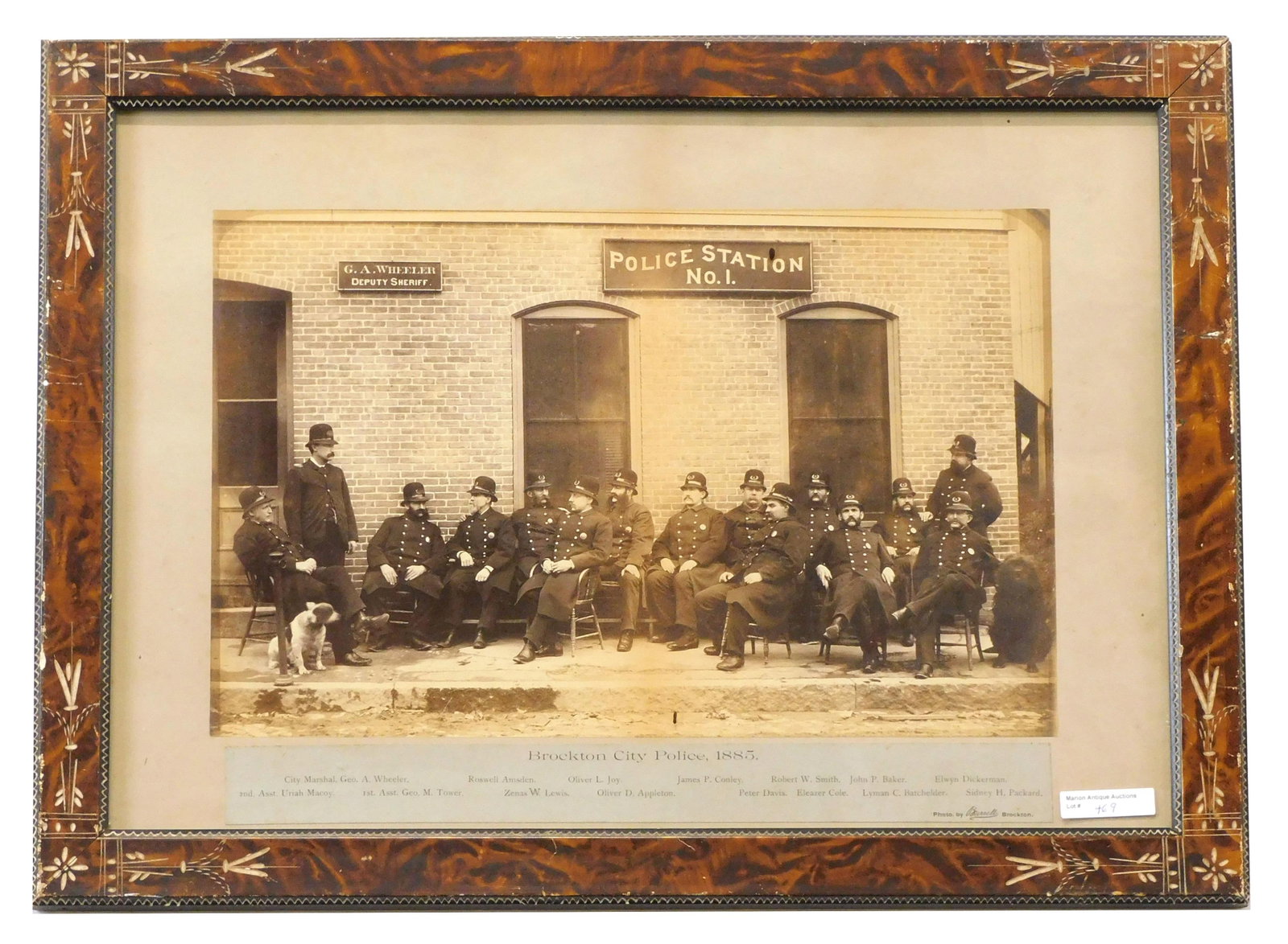 Brockton City Police Framed Photograph: 1885. Depicting Station Number 1 and its officers and dogs. Photographer Brownell, Brockton, Massachusetts. All officers are identified. Photograph: 10" high x 16" wide; identification label: 1 3/4" h