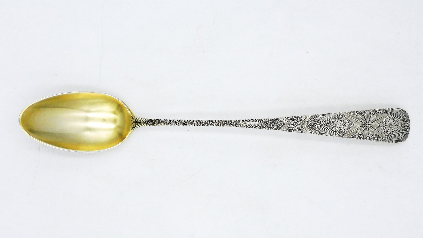 Sterling Stuffing Spoon by J.E. Caldwell: Engraved geometric floral design. Gold washed bowl. 13 1/2" long. 5.9 ozt. Provenance: A Newport, Rhode Island collection. Please note this lot must be paid for by cash, wire transfer or known check. 