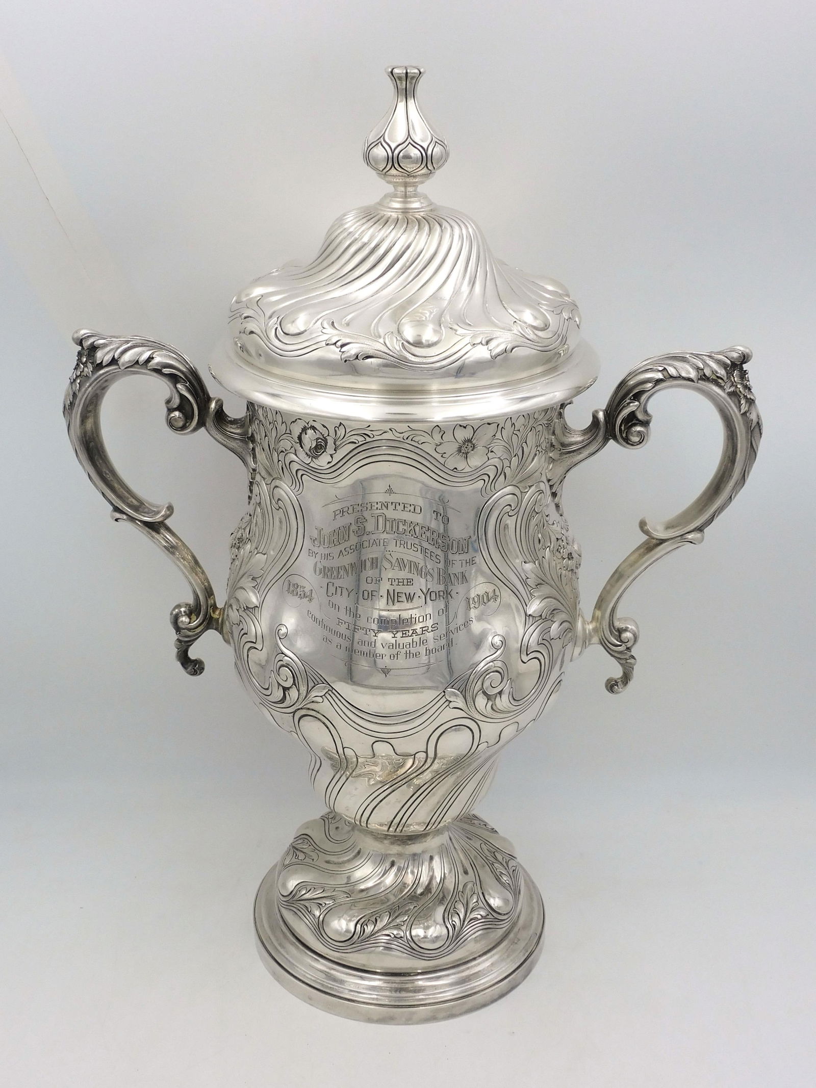 Gorham Monumental Sterling Silver Presentation Urn: With cover. Embossed Art Nouveau floral design. Gold wash interior. Inscribed: "Presented to John S. Dickerson by his associate trustees of the Greenwich Savings Bank of the City of New York on the co