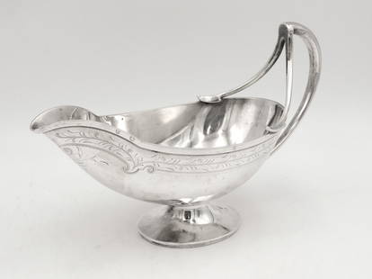 Gorham Coin Silver Gravy Boat: Engraved foliate design. 6" high x 10" long x 4" wide. 12.56 ozt. Please note this lot must be paid for by cash, wire transfer or known check. Items will be shipped or sent to shipper once payment cle