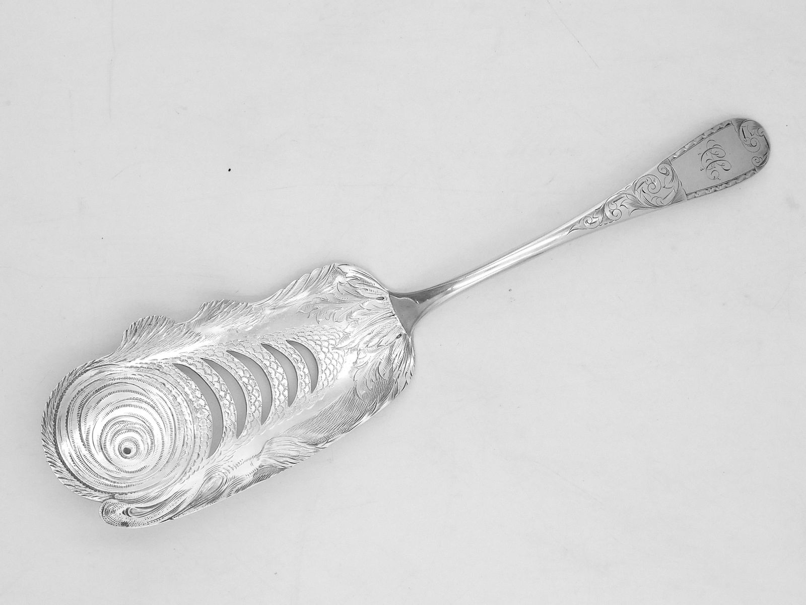 Coin Silver Fish Server: Ca. 1828-1846. S. Kirk maker. Nicely engraved with a fish design and reticulated center. 12" long x 3" wide. 5.065 ozt. Please note this lot must be paid for by cash, wire transfer or known check. Ite