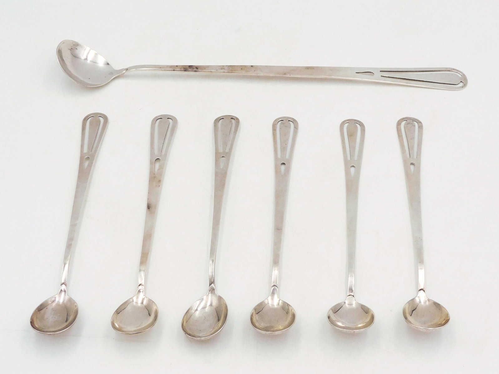 (7) Franklin Porter Sterling Iced Tea Set: 1925-1940's. Danvers, Massachusetts. Arts and Craft hand-hammered seven piece iced tea set. To include: (A) Large spoon. 11 /34" long. (B) Six matching spoons. 7 1/4" long. Total 4.23 ozt. Please note