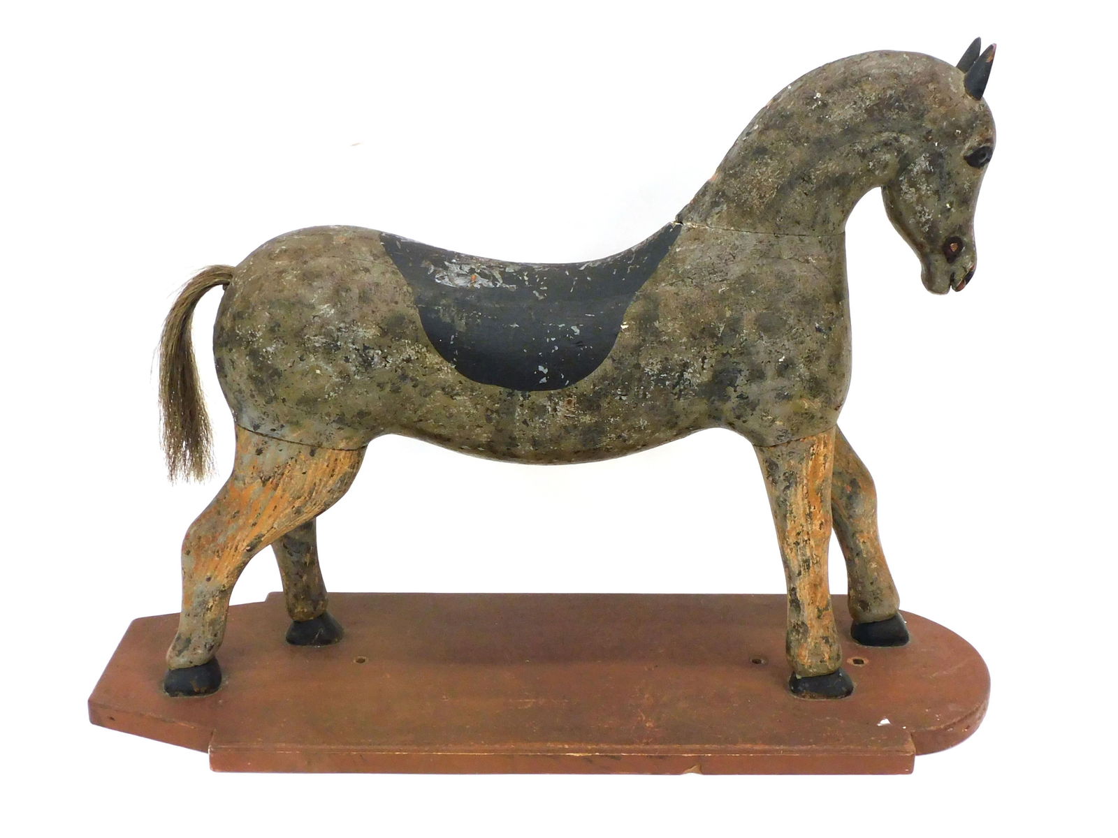 Carved Wooden Horse on Board: 19th C. Horsehair tail. Carved and painted eyes. Was once a pull toy. 21" high x 10 1/2" wide x 29" long.