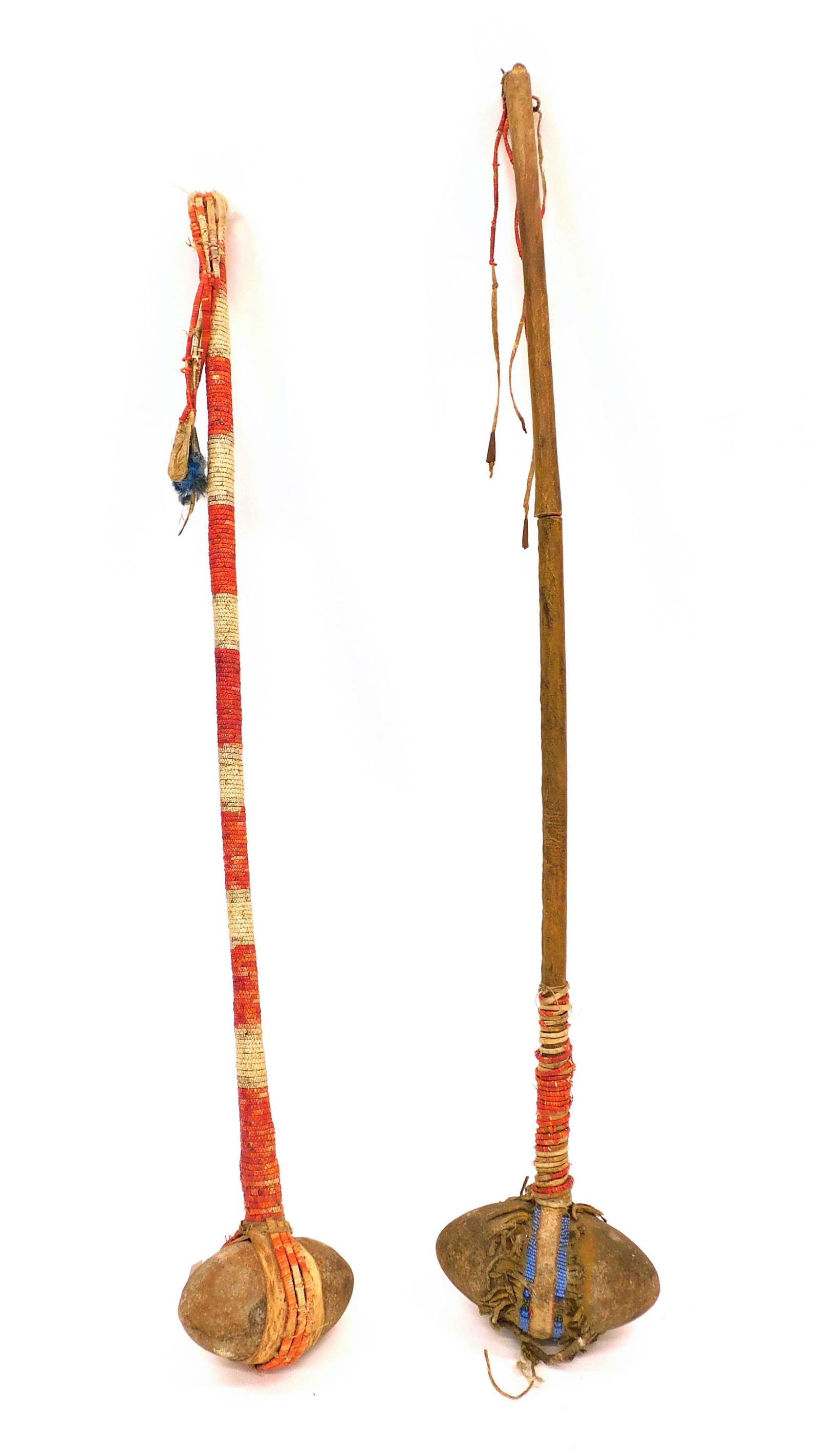 (2) Sioux War Clubs: 19th C. Both have stone heads and are quill wrapped. One has leather wrapped handle and beaded decoration. Handle in two parts. 38-40" long.