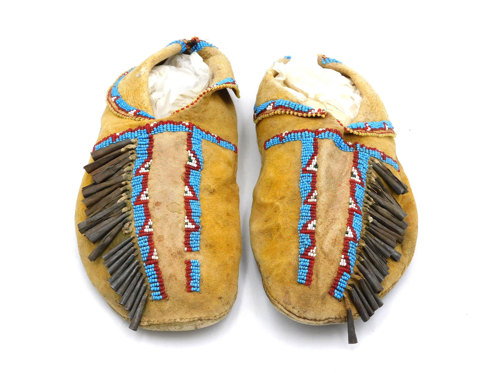 Pair of Cheyenne Beaded Moccasins: Late 19th C. With tin cone decoration. 4" wide x 11" long.