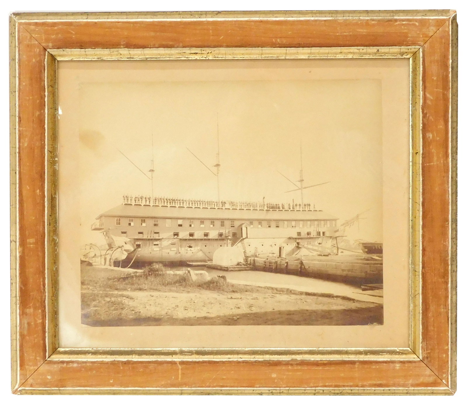 Albumen Photo of the USS Constitution: Ca. 1891. Photo shows the Constitution at the Portsmouth Naval Yard in Kittery, Maine shortly after a barn-like structure was built over the ships' spar deck after a period of preservation. Pictured o