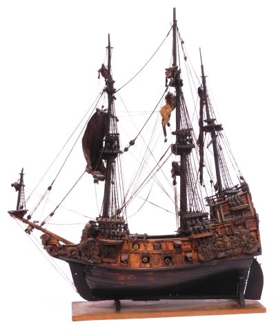 Spanish Galleon El Sol Ship Model: 17th/18th C. Wooden. Fully rigged with sails, fourteen cannons and two anchors. Elaborate applied decorative carvings. It was made to hang from the rafters of a Spanish church so that the family and f