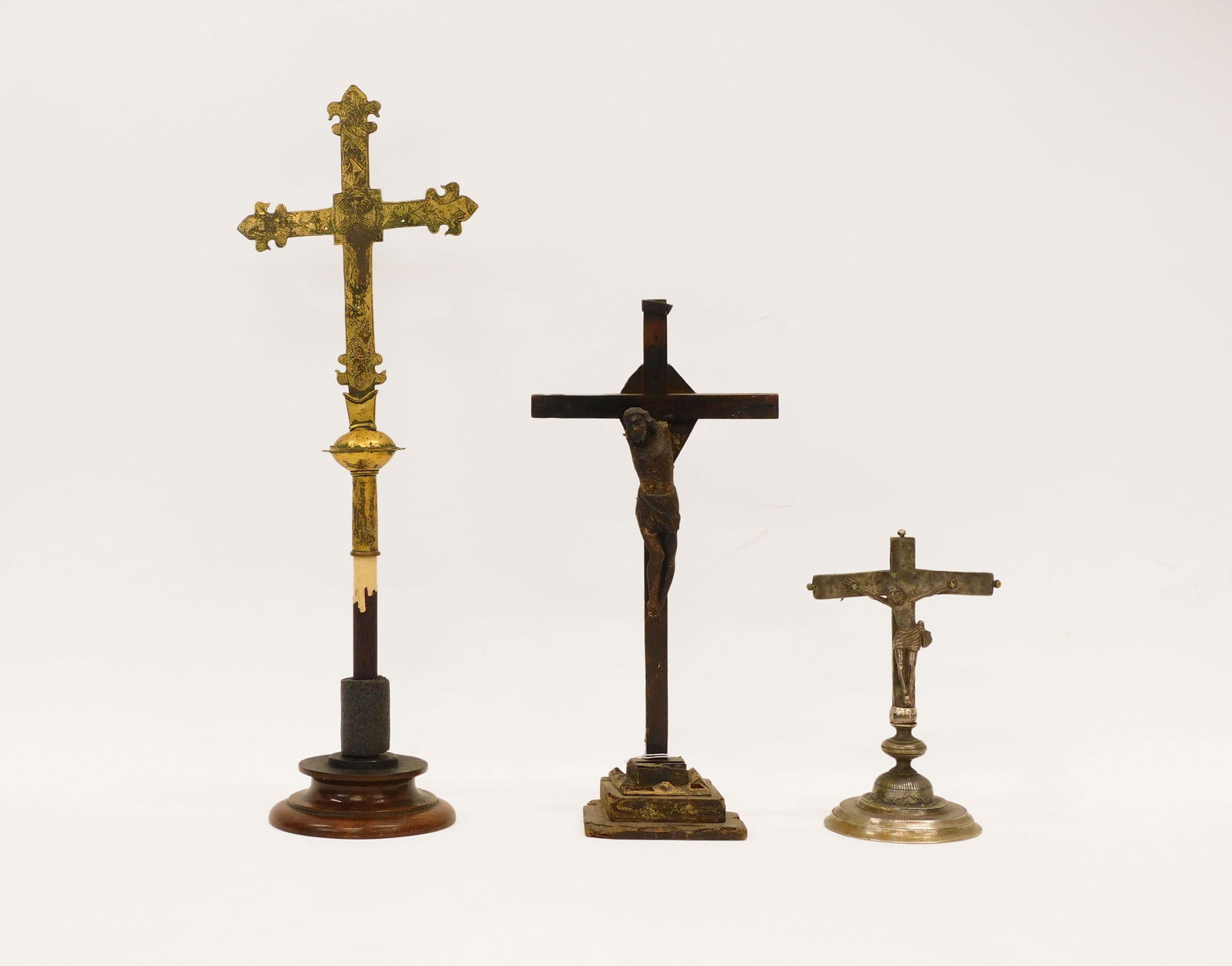 (3) Spanish Colonial Era Crucifixes: 17th/18th C. To include: (A) Silverplate. Stepped base. 9 3/4" high x 5" diameter at base. (B) Gilded metal cross with embossed design. Missing the Christ figure. On a modern wooden base. Cross measur