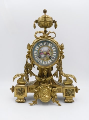 French Mantle Clock: Late 19th/Early 20th C. Ornate brass case. Hand painted porcelain dial with a courting scene. Comes with pendulum and nonmatching key. 14" high x 11 1/2" wide x 4 1/2" deep.