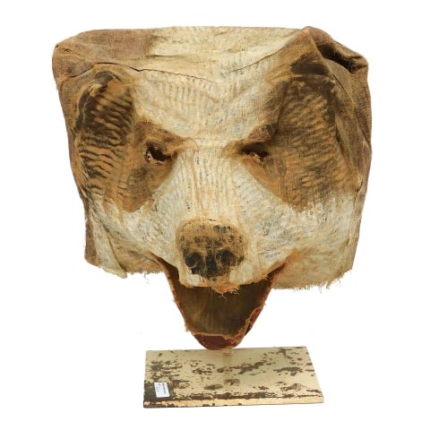 Unusual Bear Head Mask: Late 19th/Early 20th C. Fabric. Mounted on a metal base. Can be removed from the stand. 15" high x 13" wide x 14" deep. Provenance: From the estate of Rodney Hilton Brown.