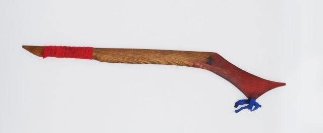 Great Lakes Ceremonial Dance Club: Late 19th/20th C. Red trade cloth wrap; blue silk ribbon. 26" long.