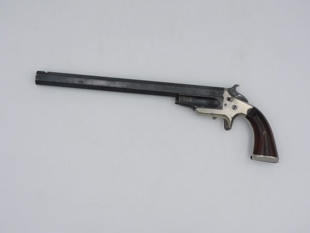 Frank A. Wesson 32 Caliber Target Pistol: Patent May 31, 1870. Serial #338. Mechanical working. 13 1/2" long. Provenance: Property deaccessioned from the Old Dartmouth Historical Society, New Bedford, Massachusetts. Proceeds to benefit the co