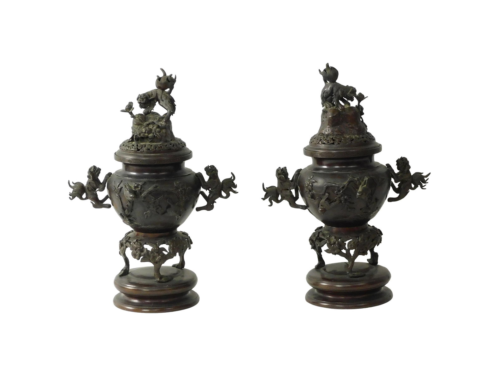 (2) Chinese Covered Bronze Urns: Late 19th C. Possible censers. Foo dog handles. Raised bird and floral design on body and lid. Mounted on circular bronze base. 18" high x 13" wide with handles x 7" diameter at base. 27.6 total lbs.G