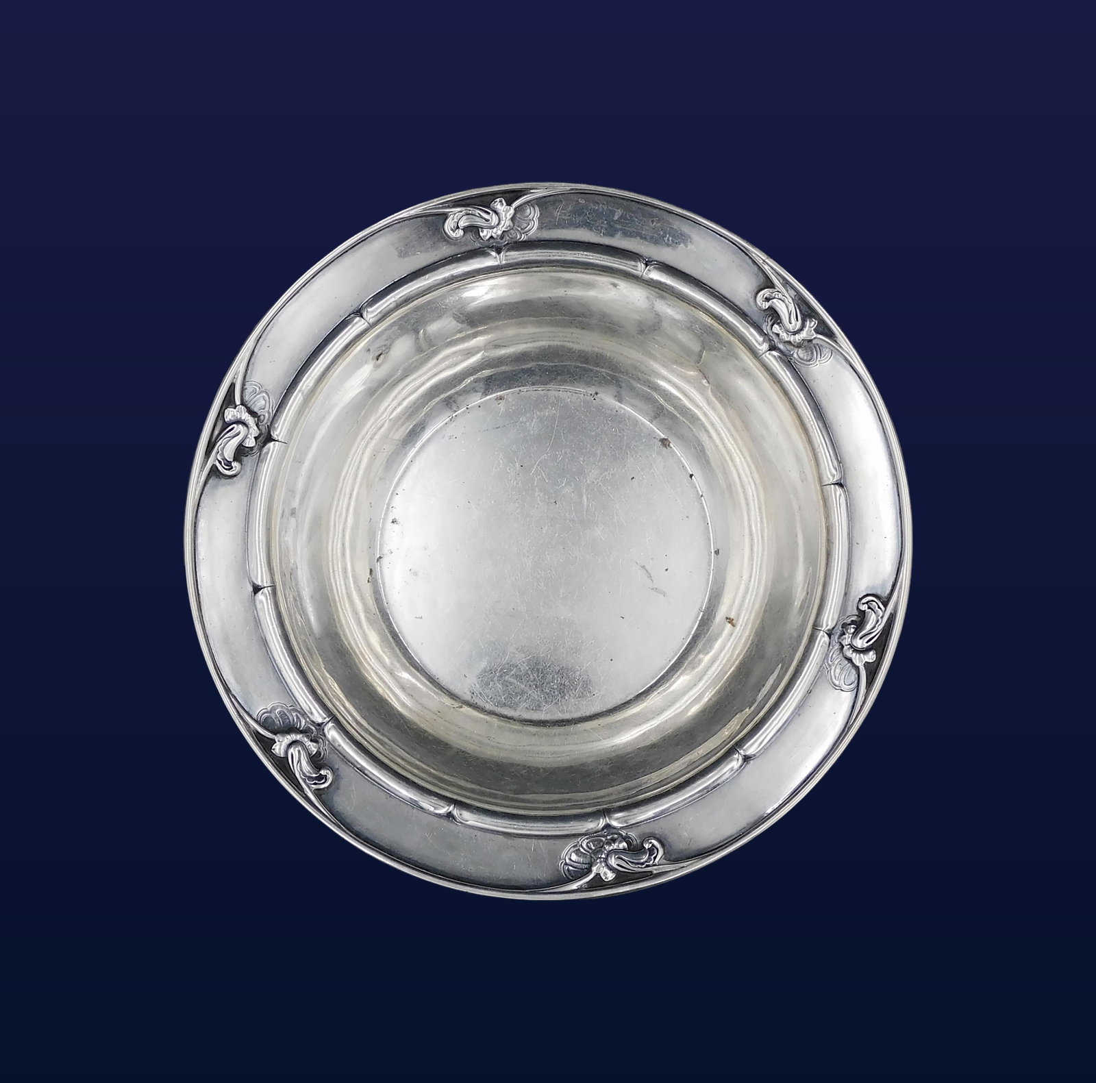 Georg Jensen Sterling Silver Bowl: Early 20th C. Denmark. Pattern no. 228 (Scroll pattern). Hand-hammered with applied scroll and floral rim decoration. Stamped on bottom: "Georg Jensen / 925 S / Denmark / 228 D." 2 1/2" high x 9" diam