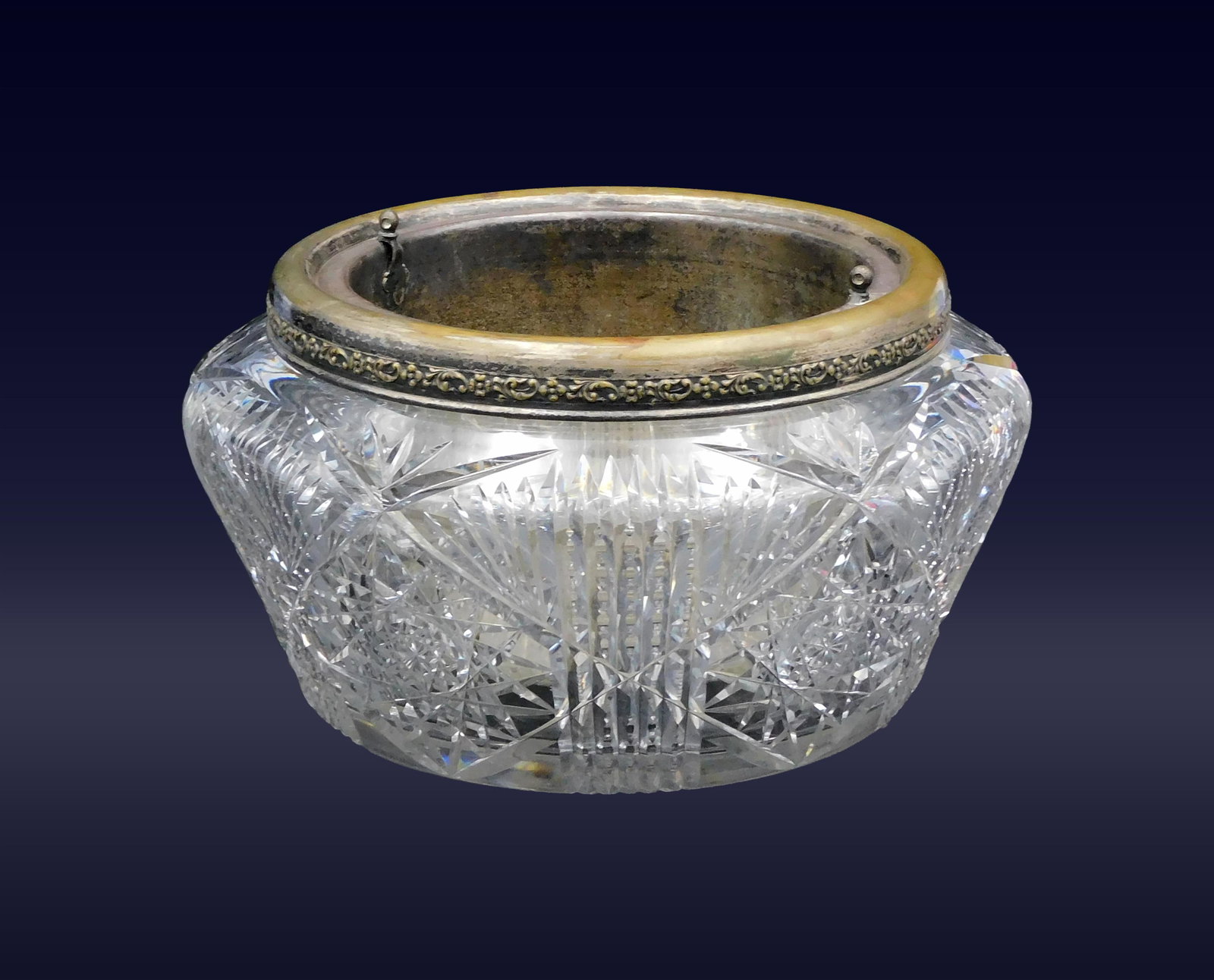 Brilliant Period Cut Glass Jardini?re: Late 19th C. American. Hobstar design. Round with silverplated rim and liner. 5 3/4" high x 10" diameter. 8.2 lbs.Glass section in good condition. Silverplated rim and liner show wear to plating. 