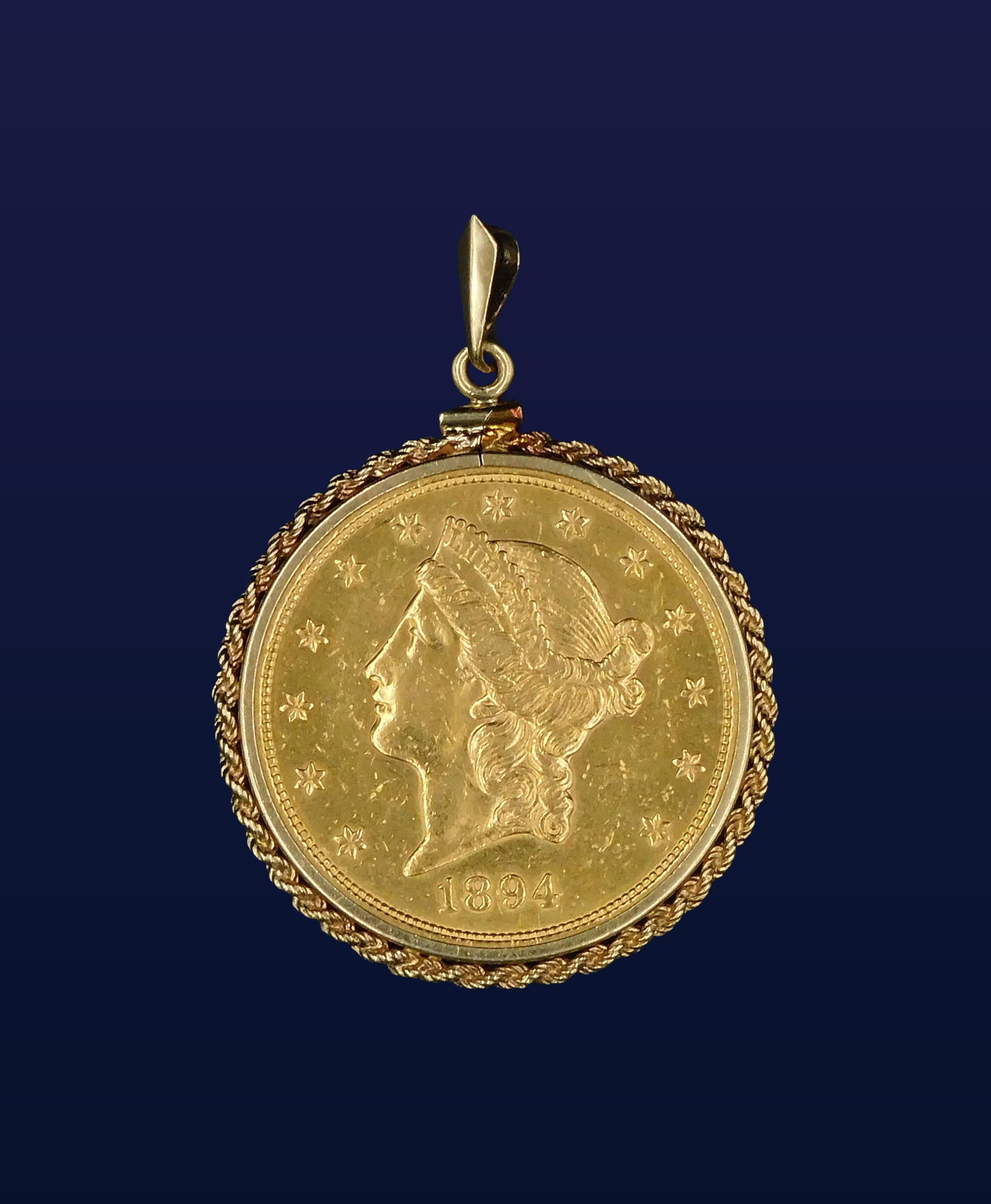 $20 Gold Piece: Ca. 1894. Double eagle. Liberty head with coronet. Housed in a 14kt gold bezel. 25.2 total dwt. Please note this lot must be paid for by cash, wire transfer or known check. Items will be shipped or